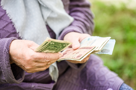 The old woman considers banknotes - hands and money close upの写真素材
