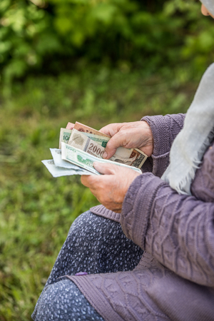 The old woman considers banknotes - hands and money close upの写真素材