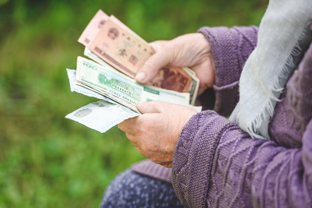 The old woman considers banknotes - hands and money close upの写真素材