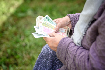 The old woman considers banknotes - hands and money close upの写真素材