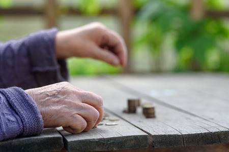 Money, coins, the grandmother on pension and the concept of life, minimum - hands of the old woman...
