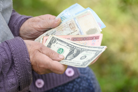 The old woman considers banknotes - hands and money close upの写真素材