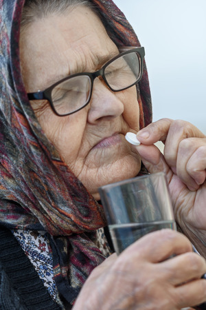 Grandmother, pill, health and the concept of a healthy lifestyle - an old woman takes pills, close-upの写真素材