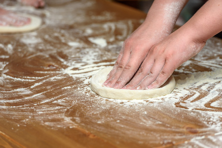 Close-up of children's hands preparing dough for pizza. Pizza, children and the concept of cooking - children make pizza.の写真素材