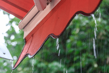 Rain drips down from the roof of a summer cafeの写真素材