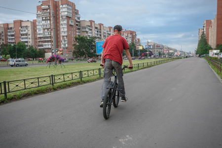 Russia, St. Petersburg, July 2018: a guy on a bicycle BMX is riding in a city parkのeditorial素材
