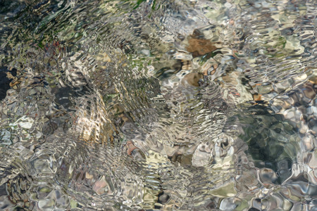 Ripples on the water, transparent river water and reefs - a natural textureの写真素材