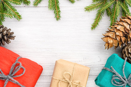 Christmas background - spruce branches, cones and gifts in a kraft paper package.の写真素材