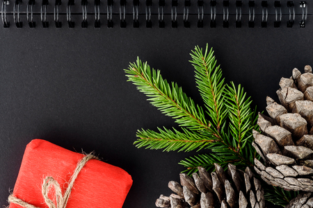 Notepad, cones, spruce branches and gifts - concept of Christmas composition top viewの写真素材