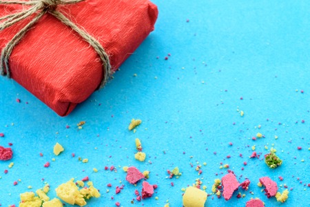 Blue background with gifts and crumbs of a multi-colored cakeの写真素材