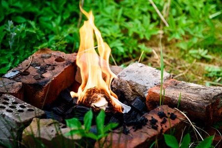 A fire built on bricks is a homemade barbecue grill. Summer picnic.の写真素材