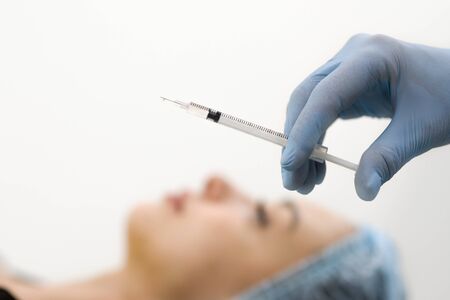 Skin care-a rejuvenation procedure using Botox injections. Squirt close-up and female face blurred backgroundの写真素材