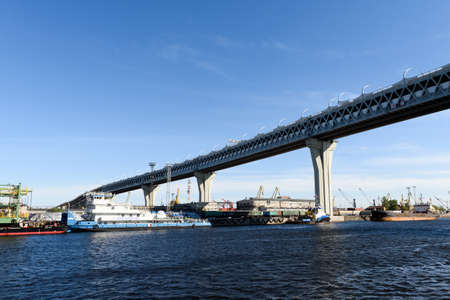 Russia, Saint Petersburg, may 30, 2020:Main road bridge over the seaport. Ships and cranes.