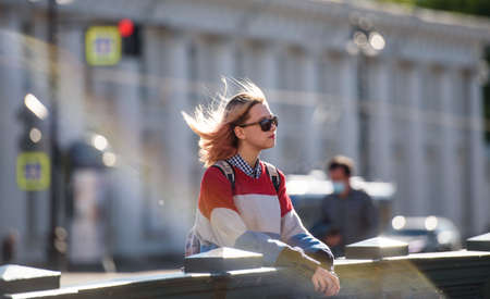 Russia, Saint Petersburg, may 30, 2020: a Young girl in sunglasses on a walk in the city at sunset.のeditorial素材