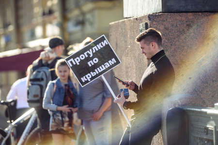 Russia, Saint Petersburg, may 30, 2020: a Young guy guide with a sign for tourists walking on the...