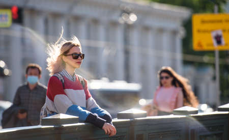 Russia, Saint Petersburg, may 30, 2020: a Young girl in sunglasses on a walk in the city at sunset.のeditorial素材