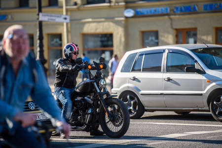 Russia, Saint Petersburg, may 30, 2020: Cars and a motorcyclist stand at a forbidding traffic light in the city.のeditorial素材
