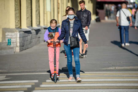 Russia, Saint Petersburg, may 30, 2020: People in the city on the sidewalk. riding scooters around the city. Pedestrian crossing.のeditorial素材