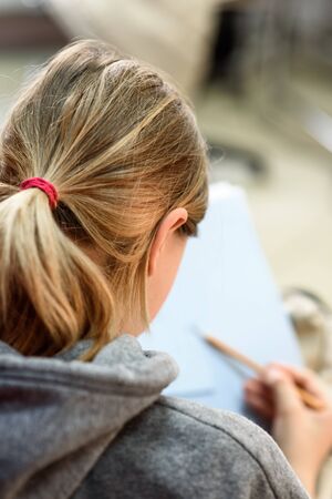 Girl draws a pencil in the album-view from the back close-upの写真素材