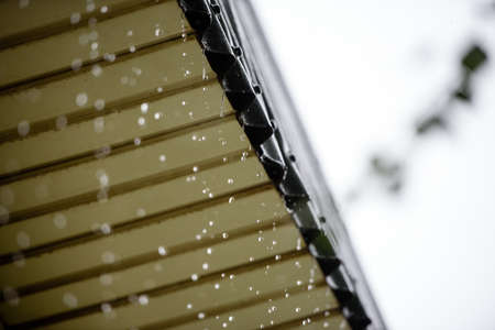 Large drops of rain fall from the roofの写真素材