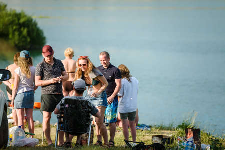 Russia, Saint Petersburg, June 24, 2020: a Group of young people in the company relax on the lake...