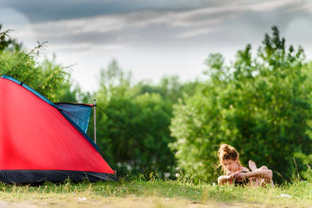 Russia, Saint Petersburg, June 24, 2020: a couple in love with a guy and a girl relax in nature with a tent.のeditorial素材