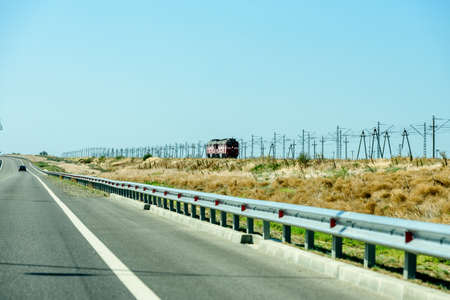 Russia, Crimea, September 11, 2019: Cars on the highway to Crimea. Railway and locomotive.のeditorial素材