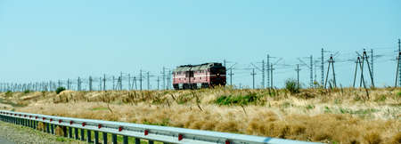 Russia, Crimea, September 11, 2019: Cars on the highway to Crimea. Railway and locomotive. Panorama.のeditorial素材