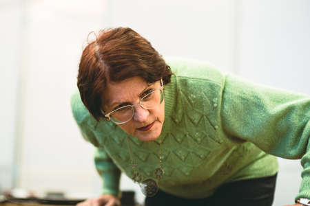 Russia, Saint Petersburg, February 8, 2020: An elderly woman with glasses is looking at something...
