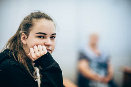 Portrait of a young girl in the classroom and the teacher in the background blurred.の写真素材