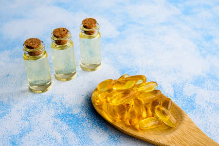 Fish oil capsules on a blue background - omega 3 vitamins and health conceptの写真素材