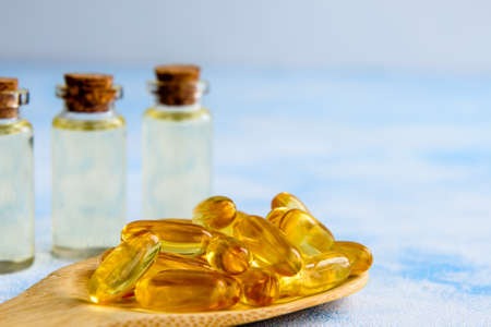 Fish oil capsules on a blue background - omega 3 vitamins and health conceptの写真素材