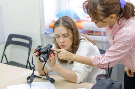 Russia, Saint Petersburg, October 2020: a Girl learns to use a camera - classroom training with a teacher. Leisure time in the educational center. Photo coursesのeditorial素材
