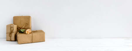 Fashionable stock background - on a white background gift boxes in kraft paper. Greeting background with copy space.の写真素材