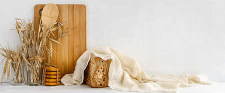 Trendy Kitchen Banner - homemade bread and wooden utensils on a white table. Stock banner and copy space.の写真素材