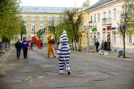 Russia, Gatchina, May 15, 2021: A man in a lion and zebra costume on a city street greets...