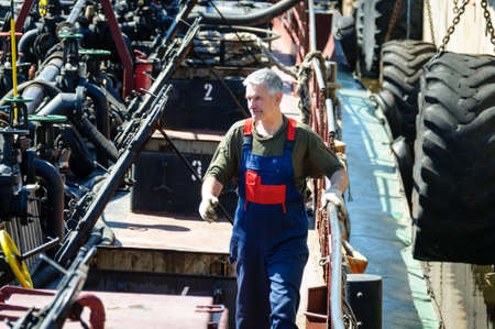 Russia, St. Petersburg, May 2021: a man in a sailor's work uniform at work on the deck of an oil sea tankerのeditorial素材