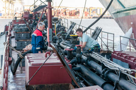 Russia, Saint Petersburg, May 2021: Two male sailors work on the deck of an oil tankerのeditorial素材