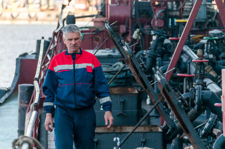 Russia, St. Petersburg, May 2021: A worker in a marine uniform on the deck of an oil tanker in the bay in the portのeditorial素材