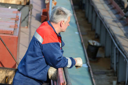 Russia, St. Petersburg, May 2021: A worker in a marine uniform on the deck of an oil tanker in the...