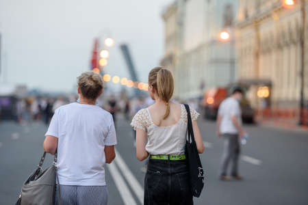 Russia, St. Petersburg, June 2021: Two young women walk along the palace embankment, a view from the backのeditorial素材