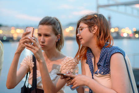 Russia, St. Petersburg, June 2021: Two young women walk along the palace embankment.のeditorial素材