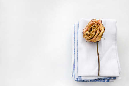 Fashionable white background with linen towels and dry flowers. Home comfort and design.