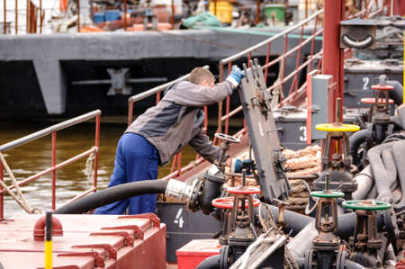 Russia, St. Petersburg, May 2021: A worker in a marine uniform on the deck of an oil tanker in the bay in the portのeditorial素材