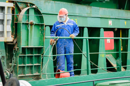 Russia, St. Petersburg, May 2021: A worker in a marine uniform on the deck of an oil tanker in the bay in the portのeditorial素材
