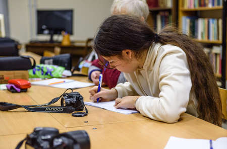 Russia St. Petersburg November 2021: A young woman in the classroom listens to photo coursesのeditorial素材
