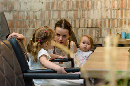 Russia, Gatchina, November 20212: A young mother with two children in a cafe at a tableのeditorial素材