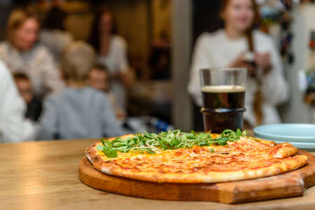 Pizzeria - pizza on the table in the foreground and the hall blurred in the backgroundのeditorial素材