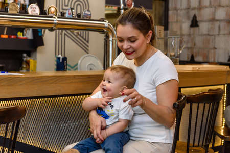 Russia, Gatchina, November 20212: A young mother with a child in a cafe makes an orderのeditorial素材