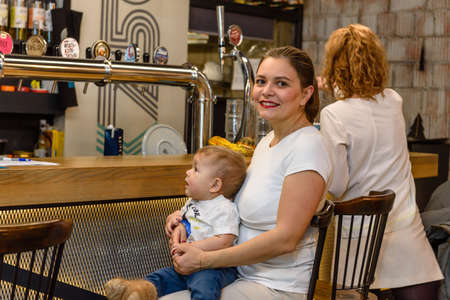 Russia, Gatchina, November 20212: A young mother with a child in a cafe makes an orderのeditorial素材